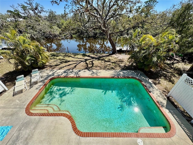 outdoor pool featuring a patio and a water view