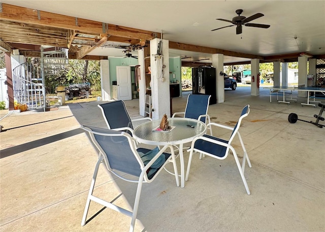 view of patio with stairs, outdoor dining area, and a ceiling fan