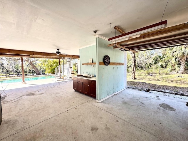 view of patio / terrace featuring stairway, an outdoor pool, and a sink