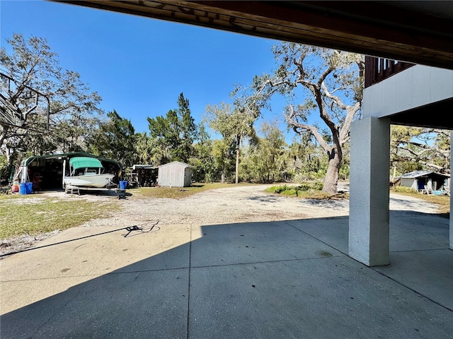 view of yard with driveway and a patio