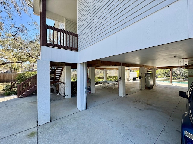 view of patio featuring stairway, a carport, a fenced in pool, and fence