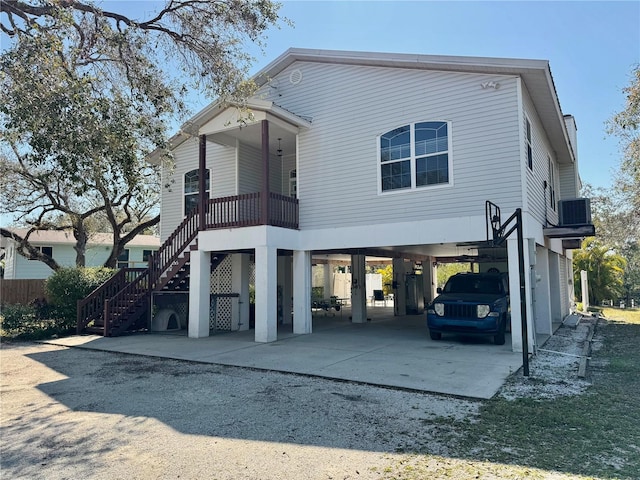 view of front of home featuring a carport, stairway, central AC unit, and driveway