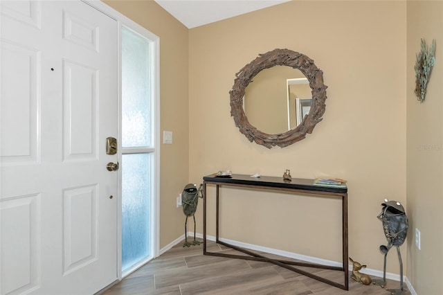 entryway featuring baseboards and wood finished floors