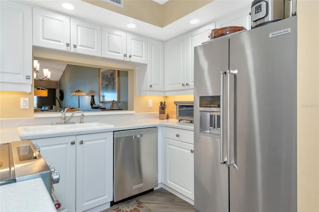 kitchen featuring a sink, recessed lighting, appliances with stainless steel finishes, white cabinets, and light countertops