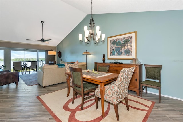 dining room with light wood finished floors, ceiling fan with notable chandelier, high vaulted ceiling, and baseboards