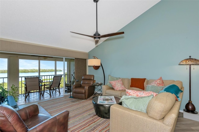 living area featuring high vaulted ceiling, a ceiling fan, and a water view