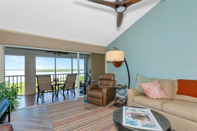 living area with a water view, lofted ceiling, wood finished floors, and a ceiling fan