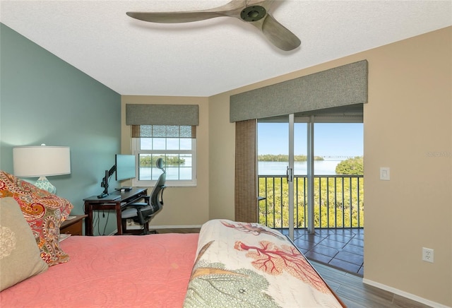 bedroom with a ceiling fan, wood finished floors, baseboards, a textured ceiling, and access to outside