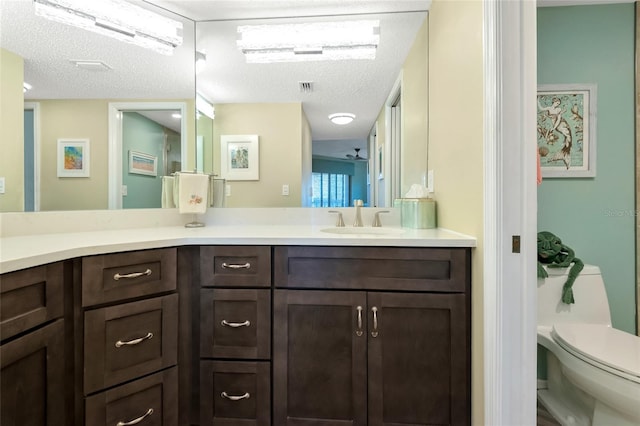 full bathroom with visible vents, a textured ceiling, vanity, and toilet