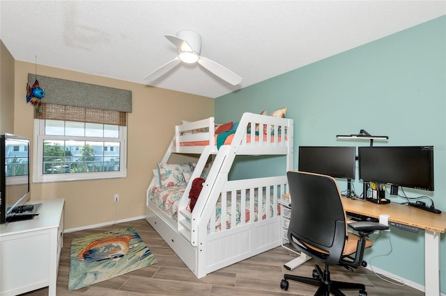 bedroom with ceiling fan, baseboards, and wood finished floors