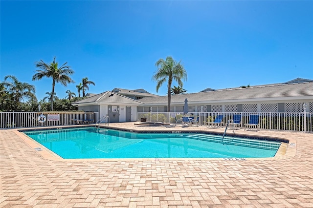 pool with a patio and fence