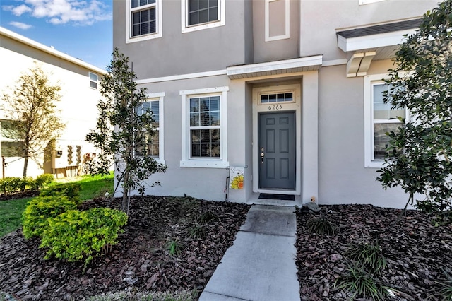 view of exterior entry featuring stucco siding