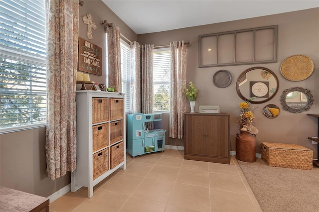 interior space with light tile patterned floors and baseboards