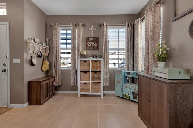 interior space featuring a wealth of natural light, baseboards, and light tile patterned floors