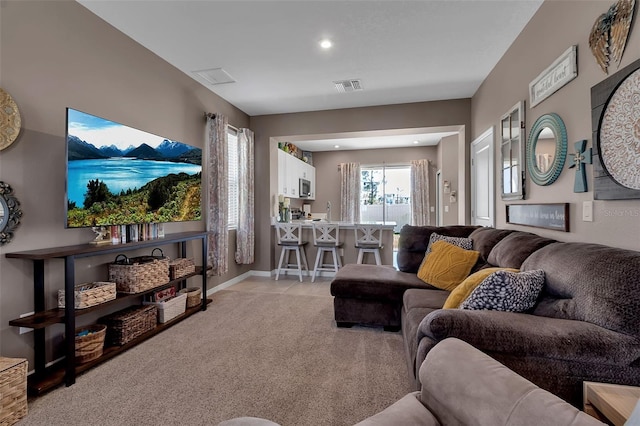 living room featuring light carpet, baseboards, visible vents, and recessed lighting