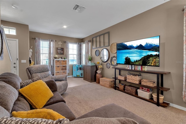 carpeted living area featuring visible vents and baseboards