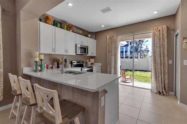 kitchen with light tile patterned floors, visible vents, stainless steel appliances, light countertops, and a sink