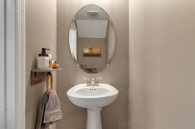 bathroom featuring a textured wall