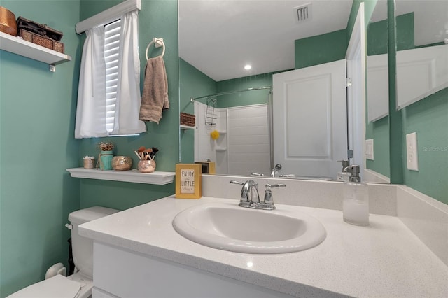 bathroom with toilet, visible vents, walk in shower, and vanity