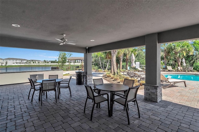 view of patio featuring a fenced in pool, a ceiling fan, and outdoor dining space