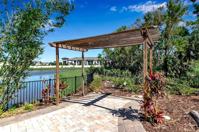 view of patio featuring a water view, fence, and a pergola