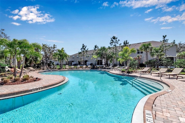 pool with a residential view and a patio