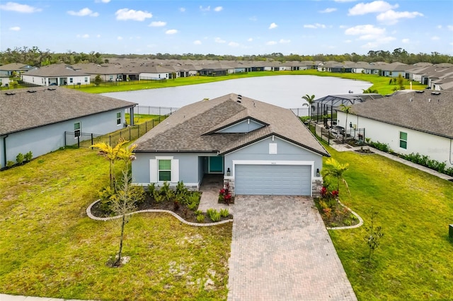 single story home with decorative driveway, a residential view, a front lawn, and an attached garage