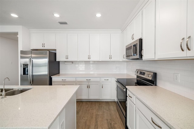 kitchen featuring visible vents, light wood-style flooring, appliances with stainless steel finishes, white cabinetry, and a sink