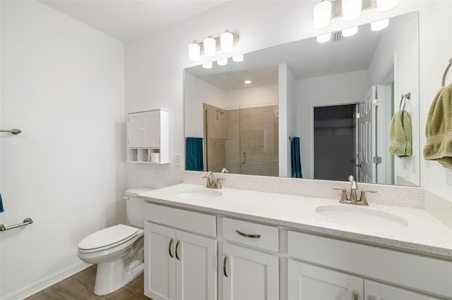 bathroom with a sink, toilet, a spacious closet, and a shower stall