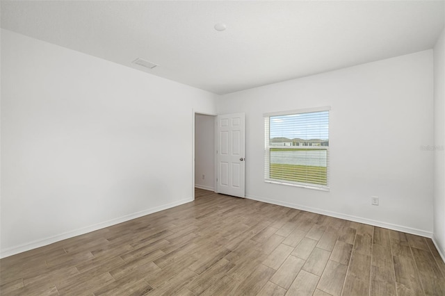 unfurnished room featuring baseboards and wood finished floors