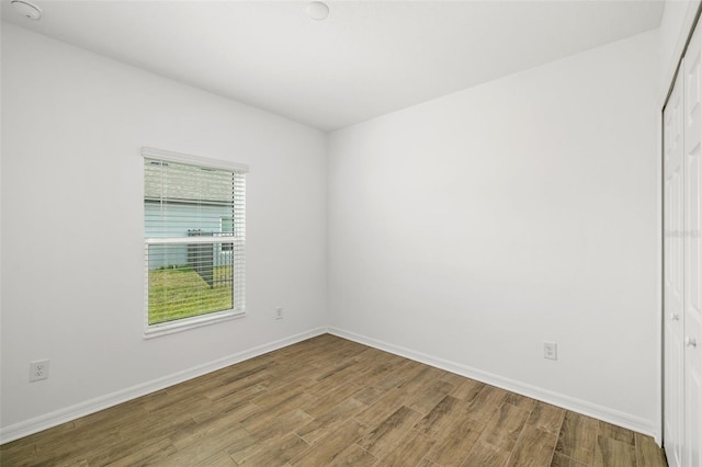 spare room with wood finished floors and baseboards