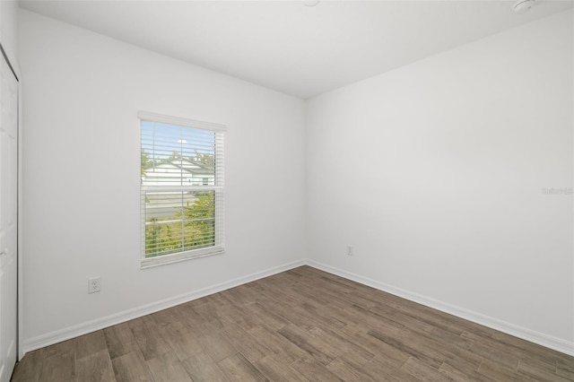 unfurnished room with baseboards and wood finished floors