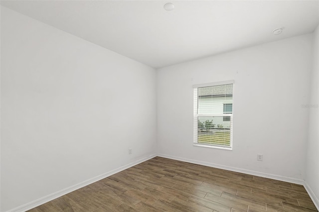 unfurnished room with baseboards and wood finished floors