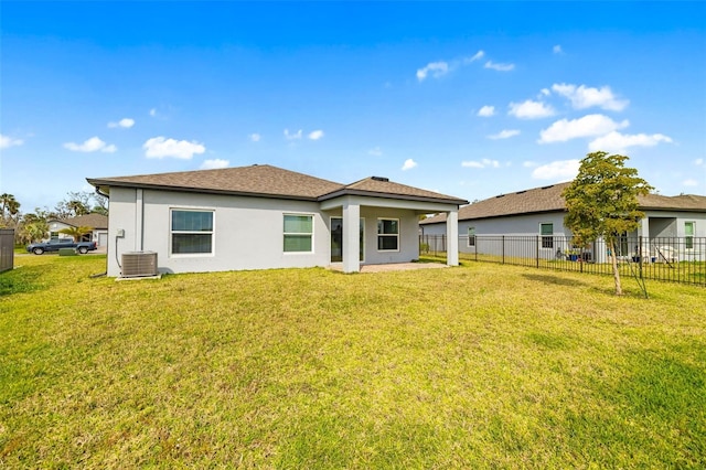 rear view of house with cooling unit, fence, a yard, and stucco siding