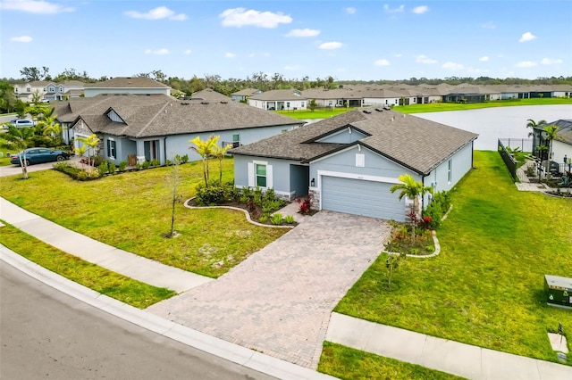 view of front of home with decorative driveway, a residential view, a garage, and a front yard