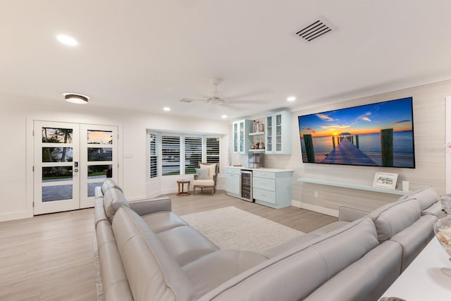 living room with beverage cooler, visible vents, light wood-type flooring, a bar, and recessed lighting