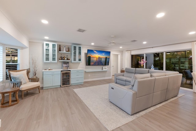 living area with recessed lighting, beverage cooler, visible vents, light wood-style floors, and a dry bar