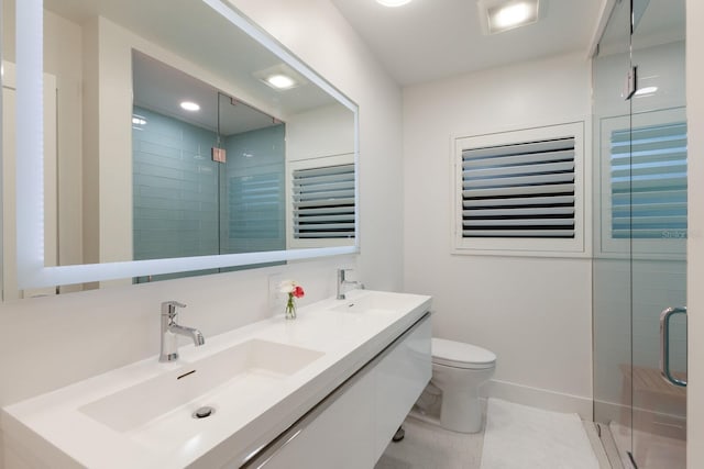 bathroom featuring double vanity, a stall shower, toilet, tile patterned floors, and a sink