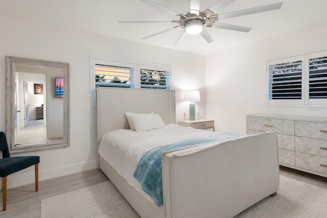 bedroom with a ceiling fan, light wood-type flooring, and baseboards