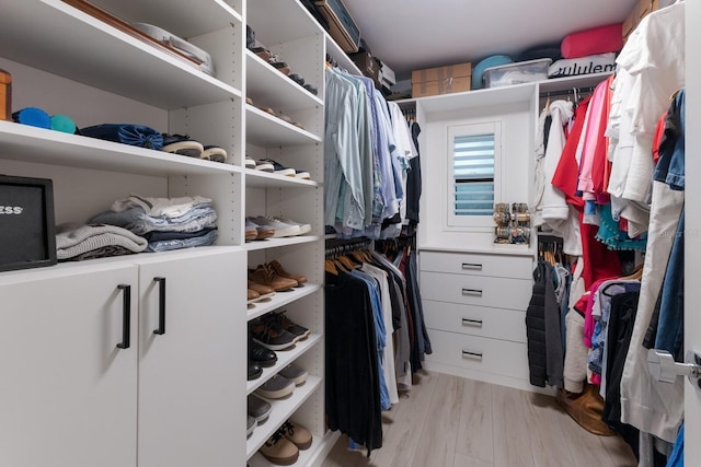 walk in closet with light wood-style floors