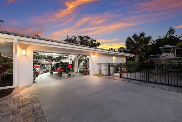 garage with freestanding refrigerator and fence