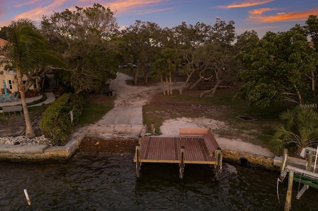 exterior space with a boat dock, a water view, and playground community