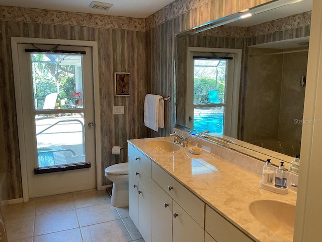 full bath featuring a wealth of natural light, toilet, wallpapered walls, and a sink