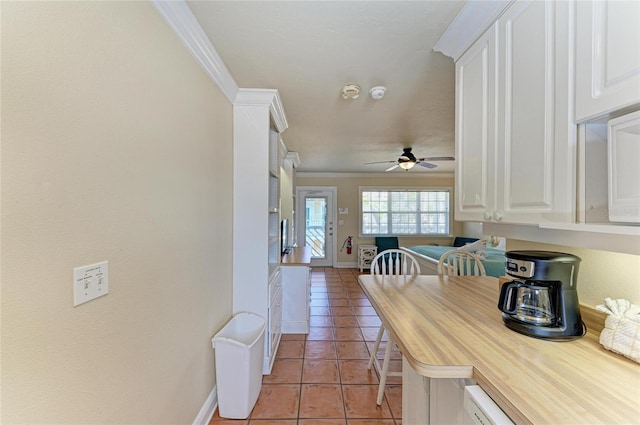 interior space featuring light tile patterned floors, ornamental molding, and baseboards