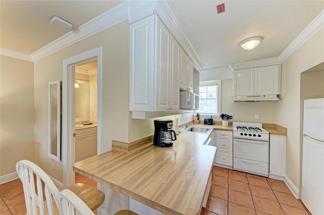 kitchen featuring white appliances, white cabinetry, under cabinet range hood, and ornamental molding