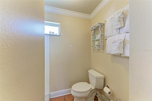 bathroom featuring tile patterned flooring, baseboards, crown molding, and toilet