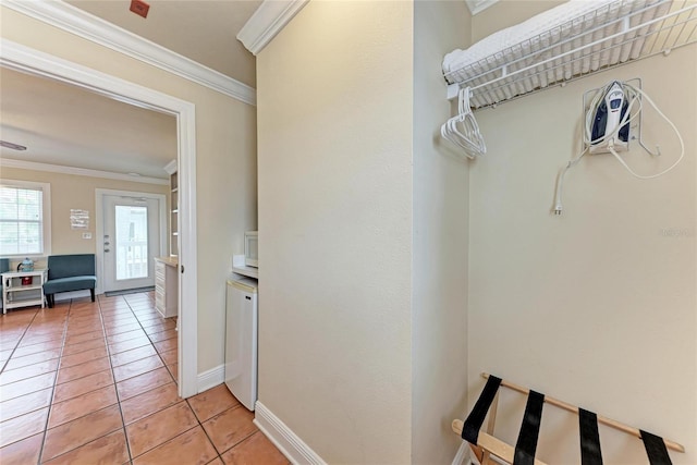 corridor with baseboards, light tile patterned flooring, and crown molding