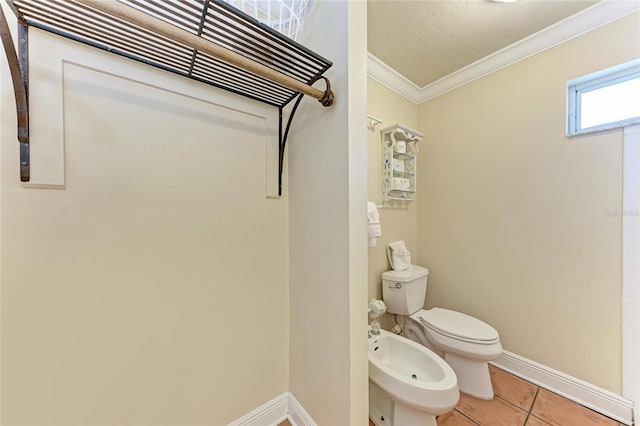 bathroom featuring toilet, ornamental molding, a bidet, tile patterned flooring, and baseboards