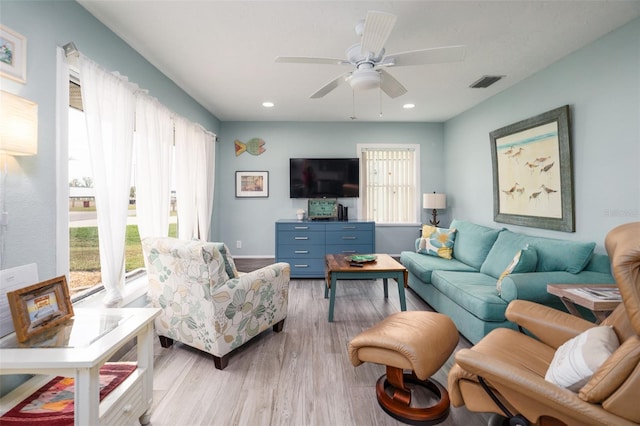 living room featuring light wood finished floors, recessed lighting, visible vents, and a wealth of natural light