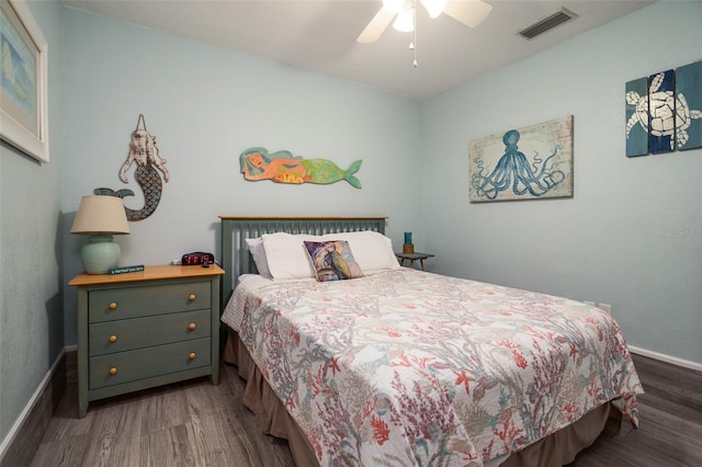 bedroom featuring visible vents, a ceiling fan, baseboards, and wood finished floors